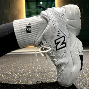 Female fit activewear socks spanning sizes 4-8.  The socks are white in colour and have a subtle DFNT. logo embroidered in Black designed to be facing out on the sock. When pulled up the socks sit just above the ankle.