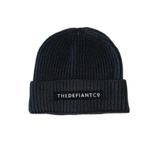 Load image into Gallery viewer, A photo showing a beanie hat. The hat has a ribbed finish with a roll cuff.  The cuff has The Defiant Co logo embroidered on the centre of the front in white on a black background. The beanie hat is charcoal.