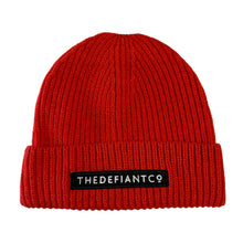 Load image into Gallery viewer, A photo showing a beanie hat. The hat has a ribbed finish with a roll cuff.  The cuff has The Defiant Co logo embroidered on the centre of the front in white on a black background. The beanie hat is red.