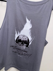 A photo showing the back of a female fit slightly cropped vest top.  The shirt has a big bold print on the back of a skull in flames. Underneath the skull is the defiant tag line 'Proudly Refusing To Obey Authority' with The Defiant Co logo under that. The vest is lava grey in colour.