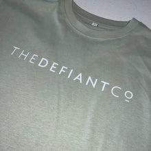Load image into Gallery viewer, A photo showing an oversized The Defiant Co T-Shirt.  The shirt has the famous ‘The Defiant Co’ logo across the front of the chest.  The shirt has a round neck and is oversized.  This particular version is the colour sage green.