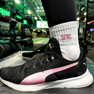 Female fit activewear socks spanning sizes 4-8.  The socks are white in colour and have a subtle DFNT. logo embroidered in pink designed to be facing out on the sock. When pulled up the socks sit just above the ankle.