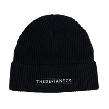 Load image into Gallery viewer, A photo showing a beanie hat. The hat has a ribbed finish with a roll cuff.  The cuff has The Defiant Co logo embroidered on the centre of the front in white on a black background. The beanie hat is black.