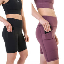 Load image into Gallery viewer, A side on view of the cycling style shorts offered by The Defiant Co.  This photo that shows the shorts in black and burgundy is demonstrating the use of the pocket that is on the right leg.