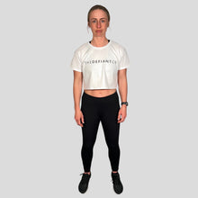 Load image into Gallery viewer, A girl wearing a cropped t-shirt .  The shirt is a female git and has a round neck and standard sleeve length.  The shirt has The Defiant Co logo across the centre of the chest.  The shirt is white colour.