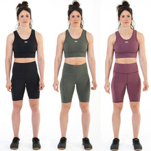 Load image into Gallery viewer, A photo collage showing a selection of female fit cycling style shorts from the front.  The shorts are designed to be tight against the skin and come in black, dark olive green and burgundy respectively.  There is a screen printed logo on the left leg reading DFNT. and there is a pocket suitable for mobile phones on the right leg.  The shorts are just above knee high.